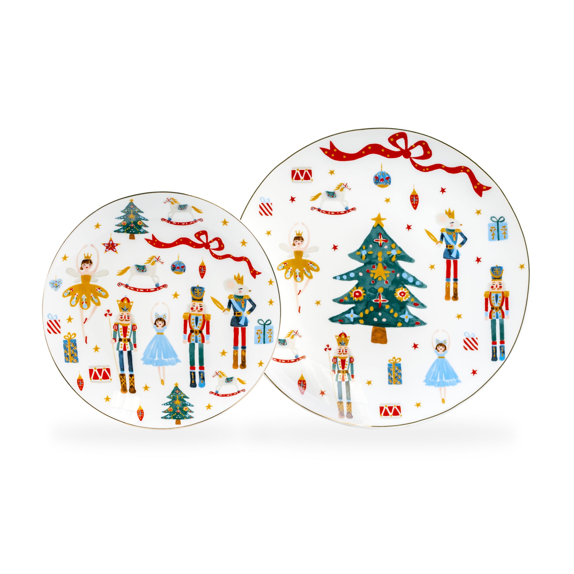 Porcelain plates with holiday-themed designs, including Christmas trees, nutcracker characters, and fairies, with gold-trimmed edges.
