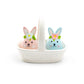 Two ceramic bunny figures with floral crowns in a white basket on a white background