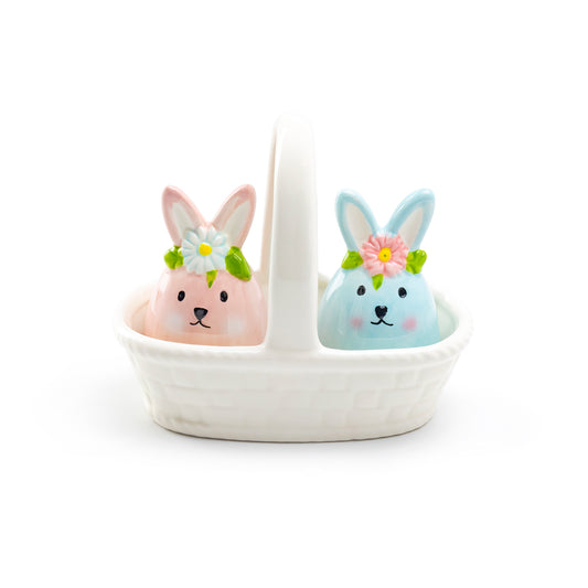 Two ceramic bunny figures with floral crowns in a white basket on a white background